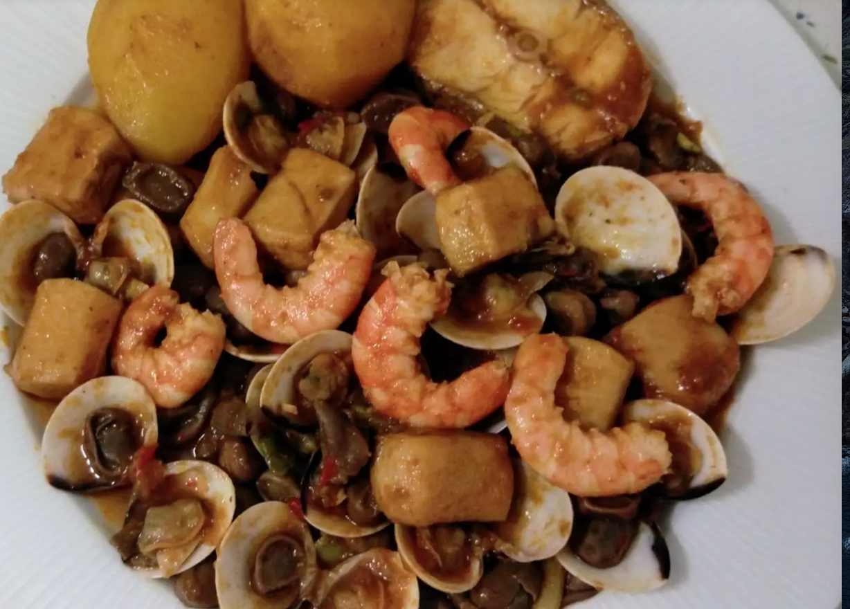 Ensalada de lechuga y tomate con guiso de pescado y marisco.